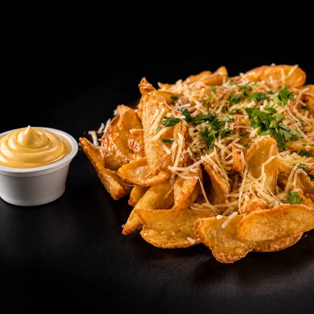 Batata canoa frita, queijo parmesão ralado, azeite trufado, maionese trufada e salsinha. Aprox. 370g