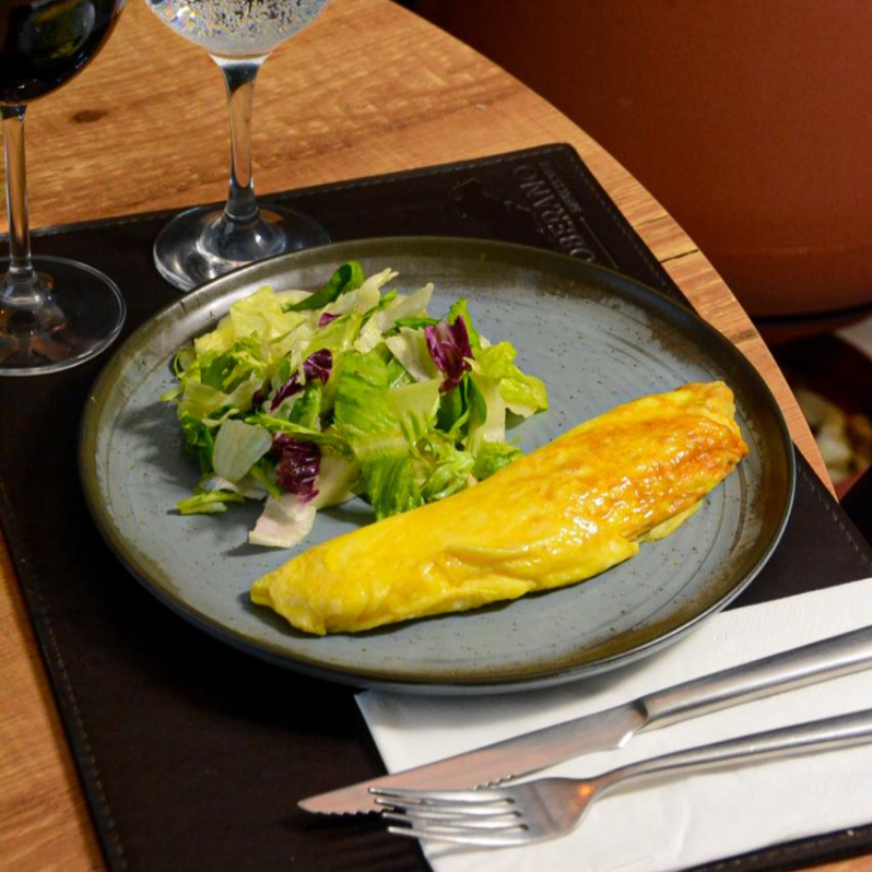 Omelete cremoso tradicional, acompanhado de salada de folhas.