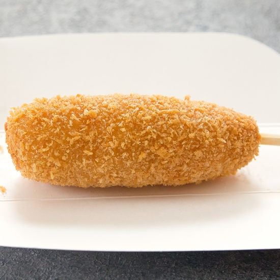 Salsicha inteira no palito envolto em massa coreana e frito.