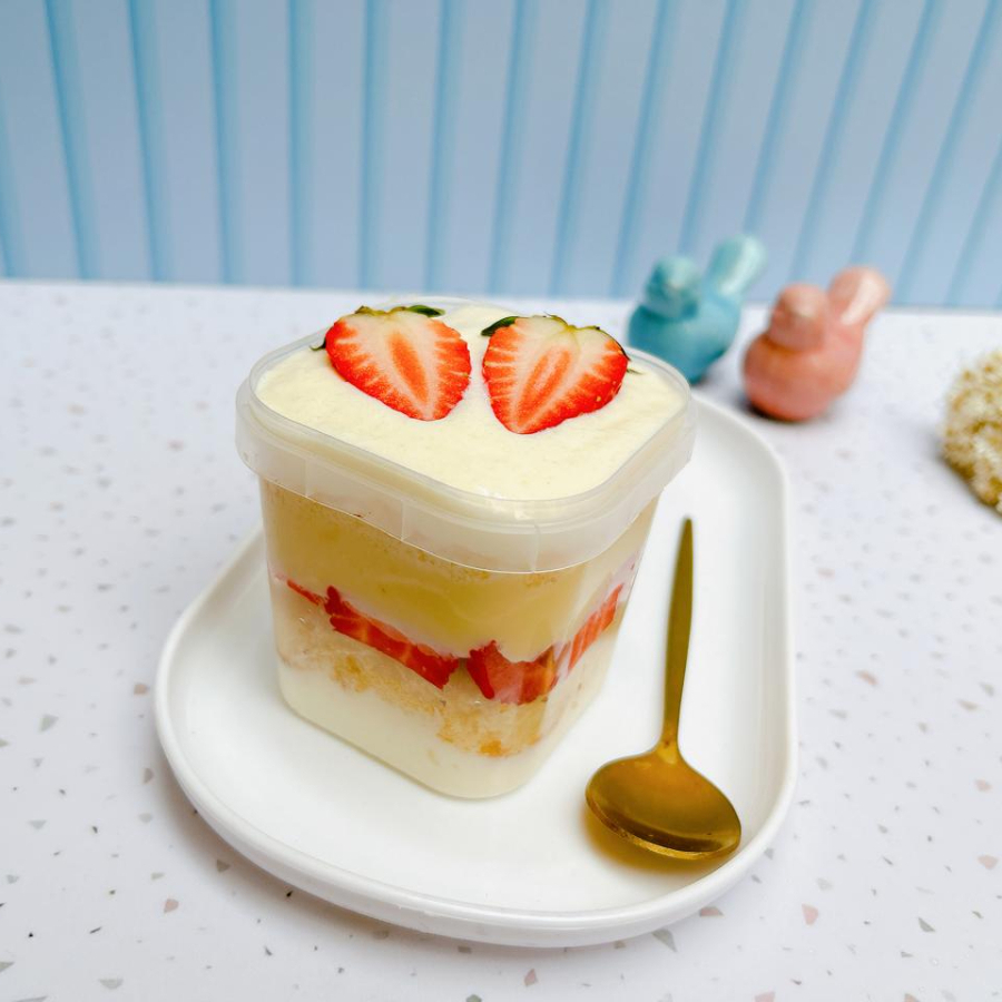 Bolo no pote com massa branca, camadas de creme de Ninho, brigadeiro de Ninho e morangos frescos.