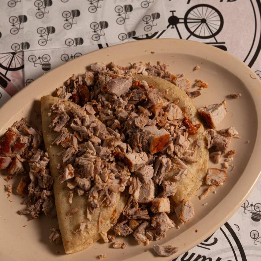 Taco dorado de frijol con carnitas
