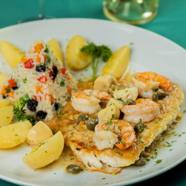 filé de badejo grelhado com molho de camarões, champignon e alcaparras flambados no vinho branco e leve toque de molho madeira com gotinhas de limão, guarnecido com arroz à grega e batata souté