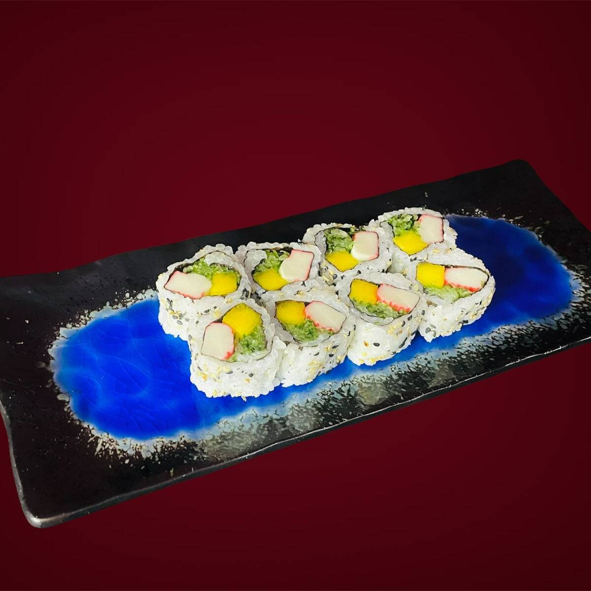 Uramaki com recheio de kani, abacate e pepino, coberto com gergelim.