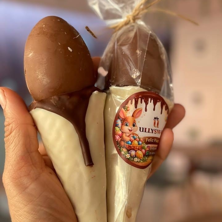 A casquinha de waffer é banhada em chocolate branco, oferecendo uma combinação deliciosa e crocante. O recheio de brigadeiro cremoso é confeitado com Kinder Ovo, que trazem um toque de recheio de ninho e Nutella. Cada mordida proporciona uma experiência única, perfeita para quem aprecia doces sofisticados e saborosos. Ideal para compartilhar ou saborear em momentos especiais.