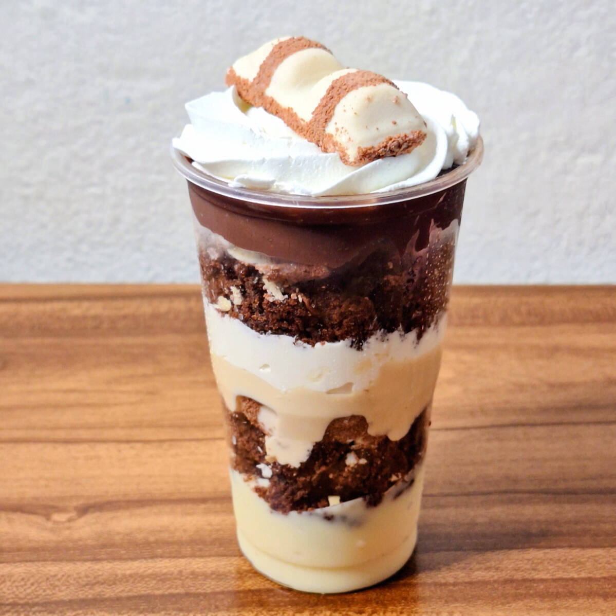 Copo de 300 ml recheado com brigadeiro cremoso de leite ninho, pedaços de brownie, recheio bueno da Caribe, mousse de leite ninho, pedaços de kinder bueno, brigadeiro cremoso de chocolate e finalizado com chantilly.