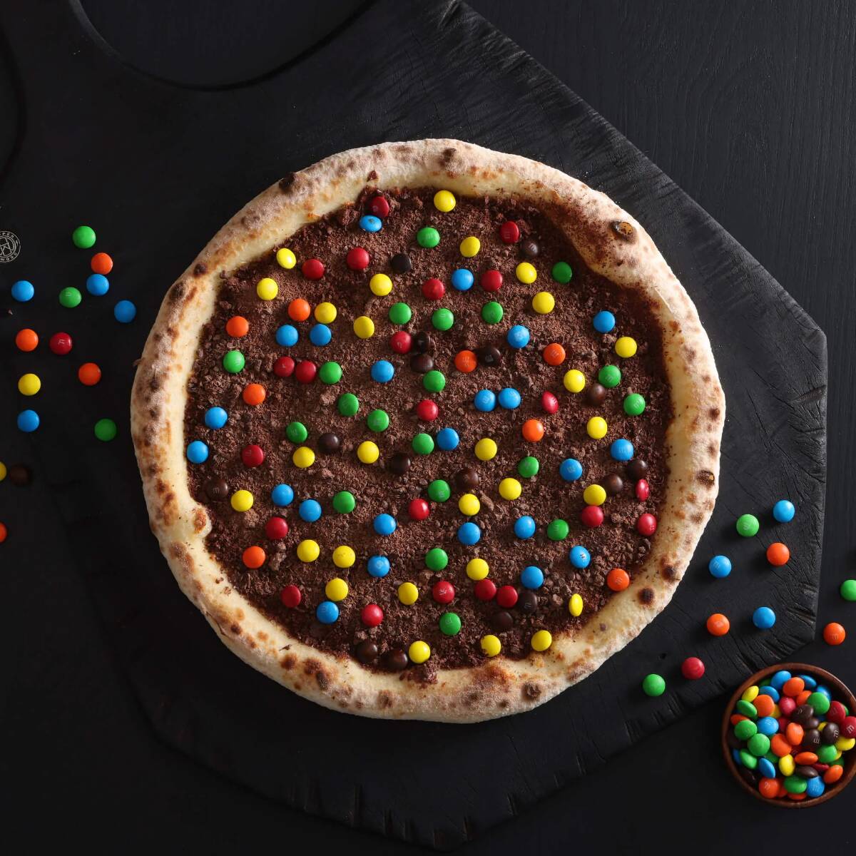 Uma "Explosão de Alegria": a base clássica de muçarela encontra o derretimento das raspas de chocolate, o crocante dos confetes e o toque final de leite condensado. O equilíbrio perfeito entre o salgadinho e o doce extremo!