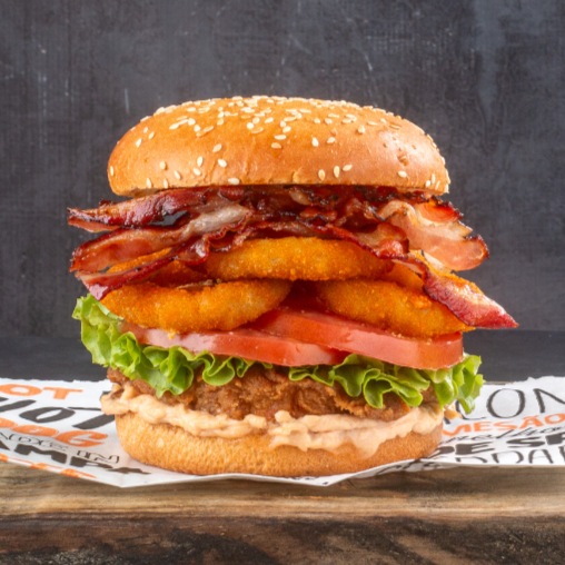 Tudo que você ama! 2 tiras de frango empanado, queijo, onion rings crocantes, bacon, alface, tomate e maionese Black Dog. No pão brioche, com ou sem gergelim. É o lanche completo — e delicioso — do início ao fim!