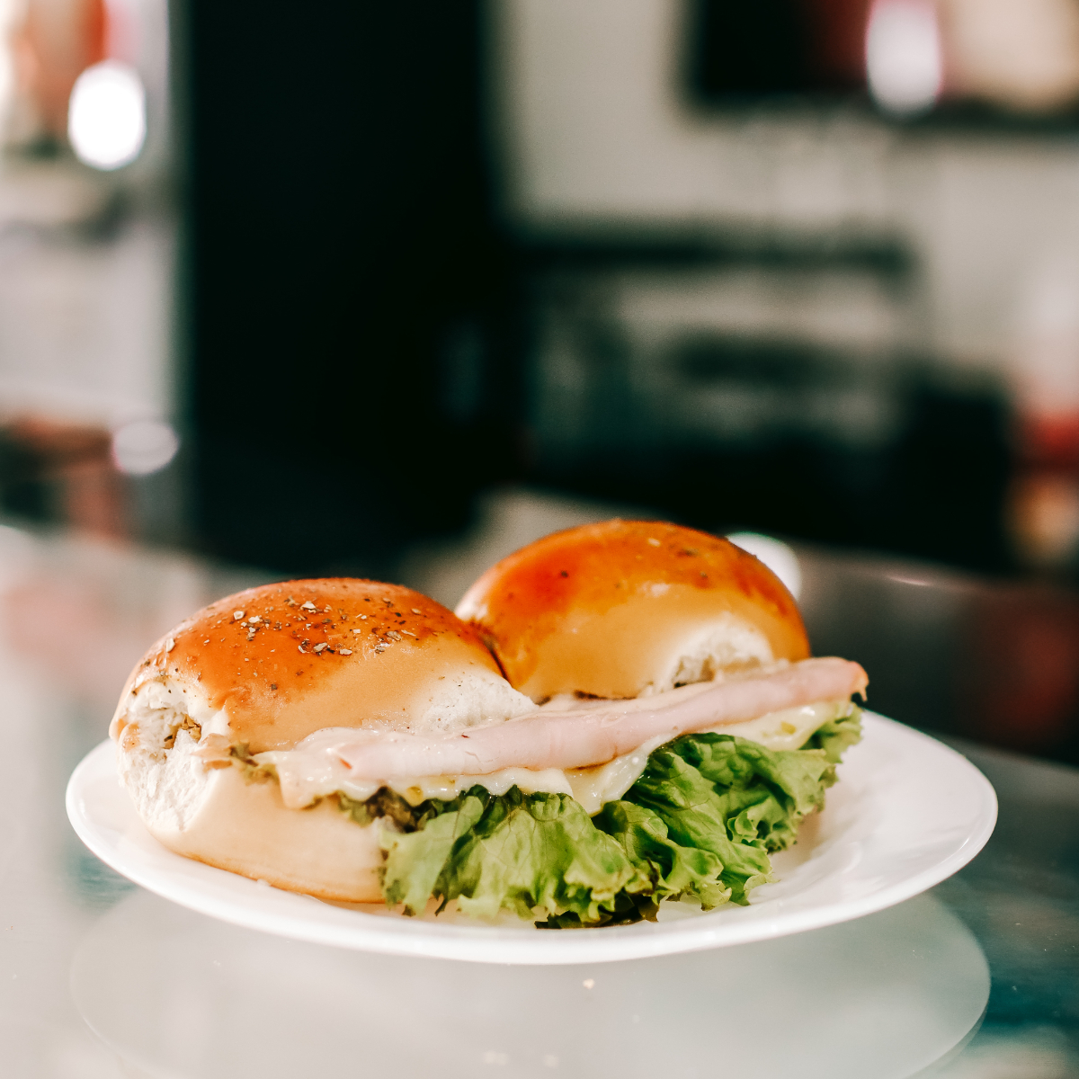 Mini pão de hamburgue, queijo, presunto, alface, creme cream cheese 2 unidade por badeja.