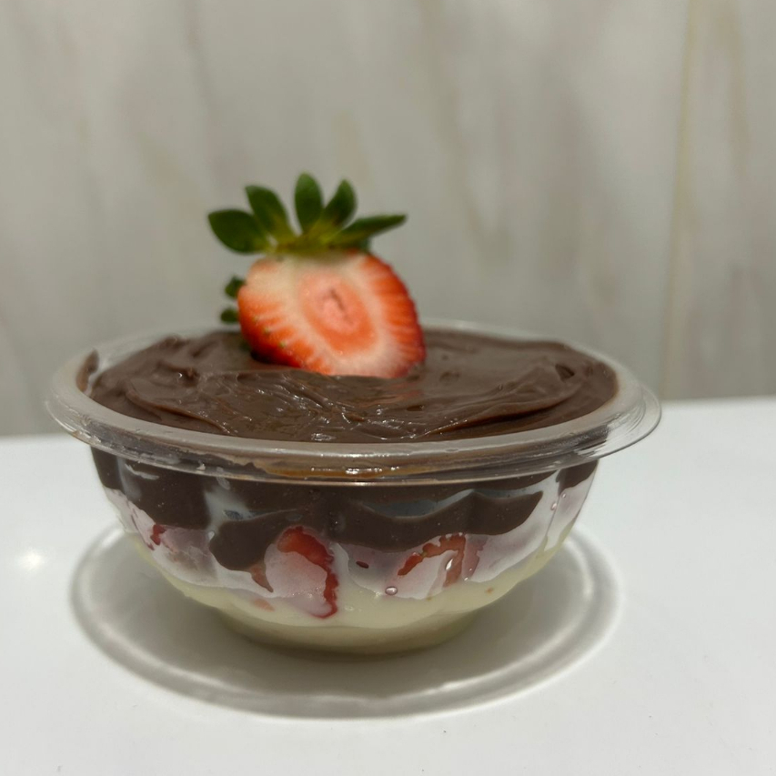 Creme de ninho com morangos frescos e picados, creme de chocolate com Granule e um morango no topo