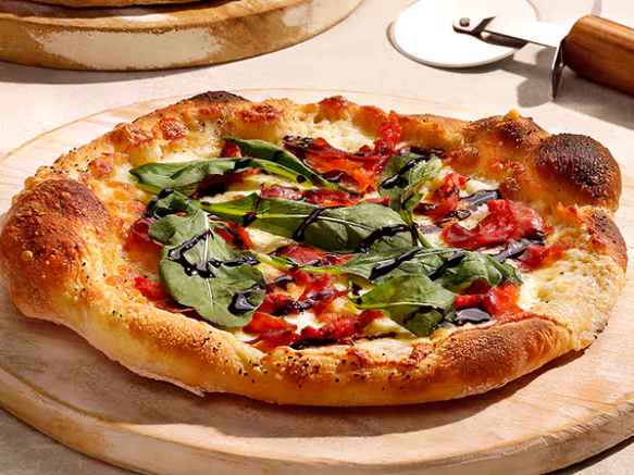 Prosciutto acompanhado de rúcula e tomate seco, queijo mozzarella, finalizado com molho pesto e redução de balsâmico. Com Stella Artois na massa.