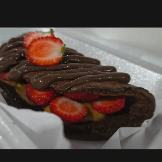 Panqueca a base de ovos , chocolate 50% cacau e farinha de aveia: recheada com doce de leite cremoso e morangos.