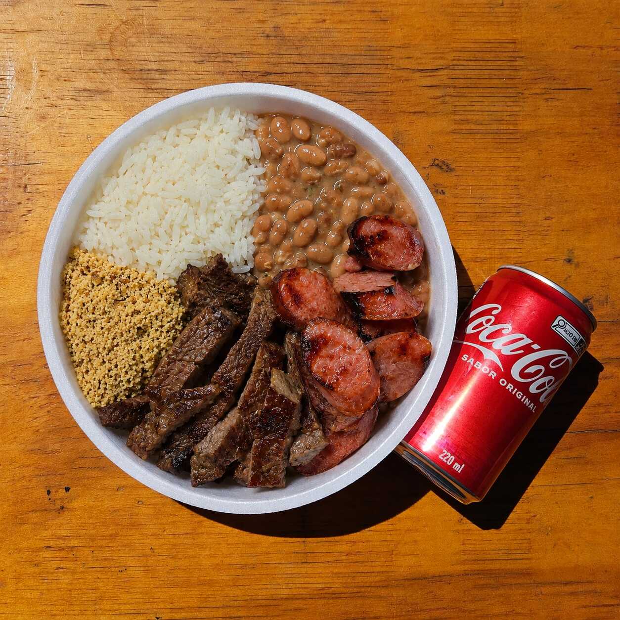 Arroz soltinho, tiras de contrafilé, linguiça de churrasco e farofa temperada. Prato completo, saboroso e bem servido. Porção de 600 g. Serve 1 pessoa.