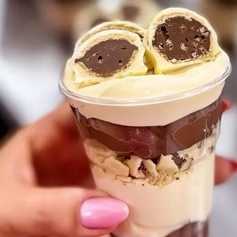 Pedaços de brownie crocante e macio, brigadeiro de outro branco e brigadeiro preto feito com cacau 50%. Finalizado com o clássico bombom ouro branco