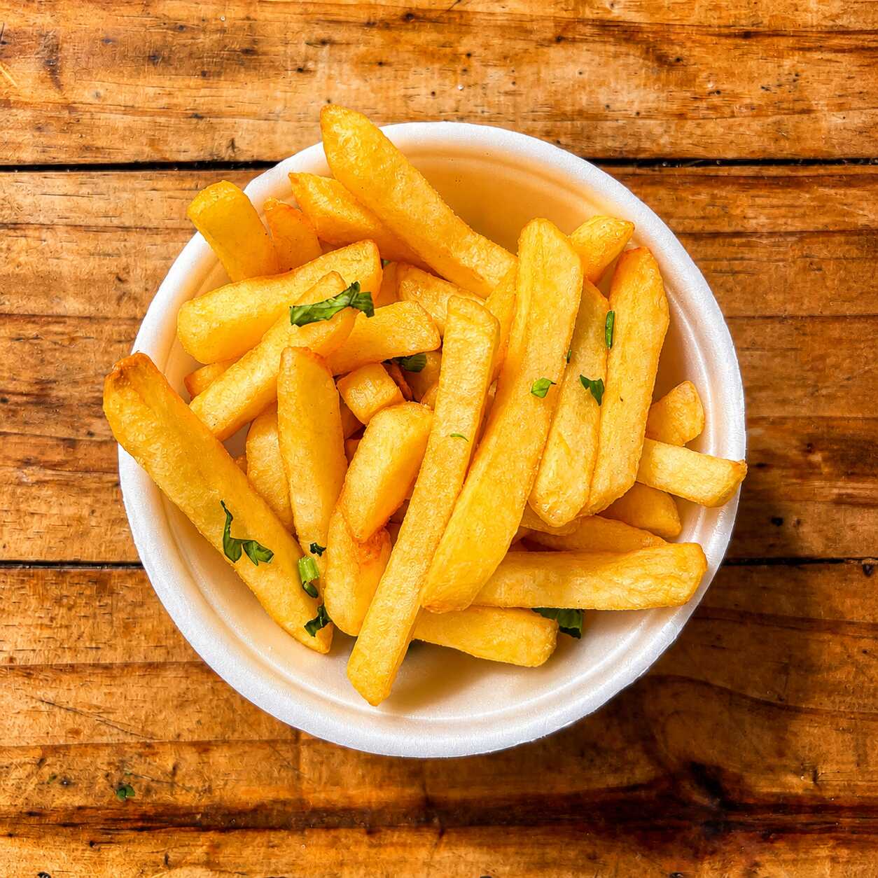 Porção de batatas fritas douradas, crocantes por fora e macias por dentro. Ideal para acompanhar sua refeição ou compartilhar.