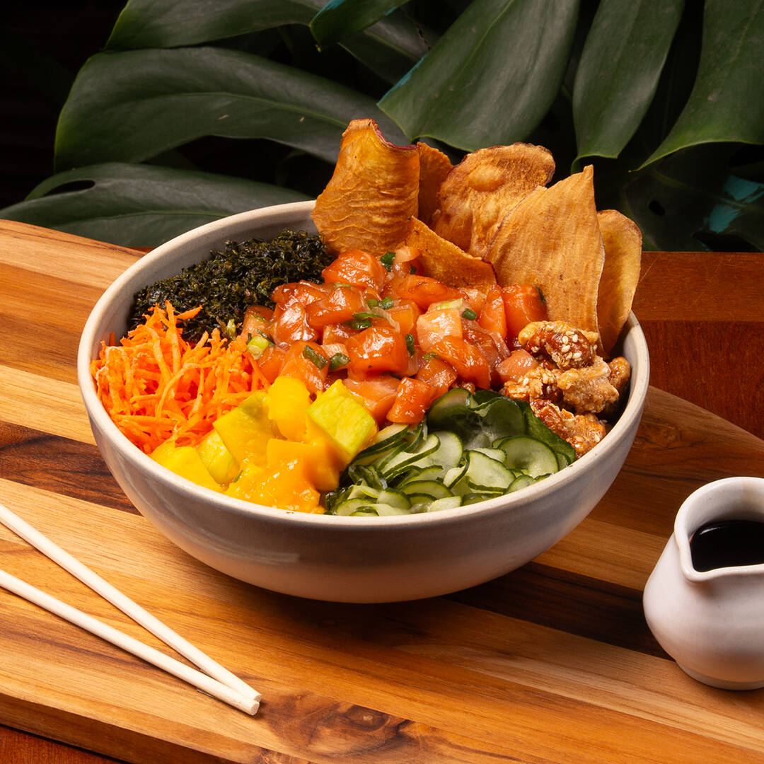 Salmão, arroz japonês temperado (shari), manga, sunomono, cenoura, castanha de caju caramelizada com gergelim, crisp de couve e chips de batata doce. Molho Let's Poke. Não fazemos troca de itens nos pokes do chef.