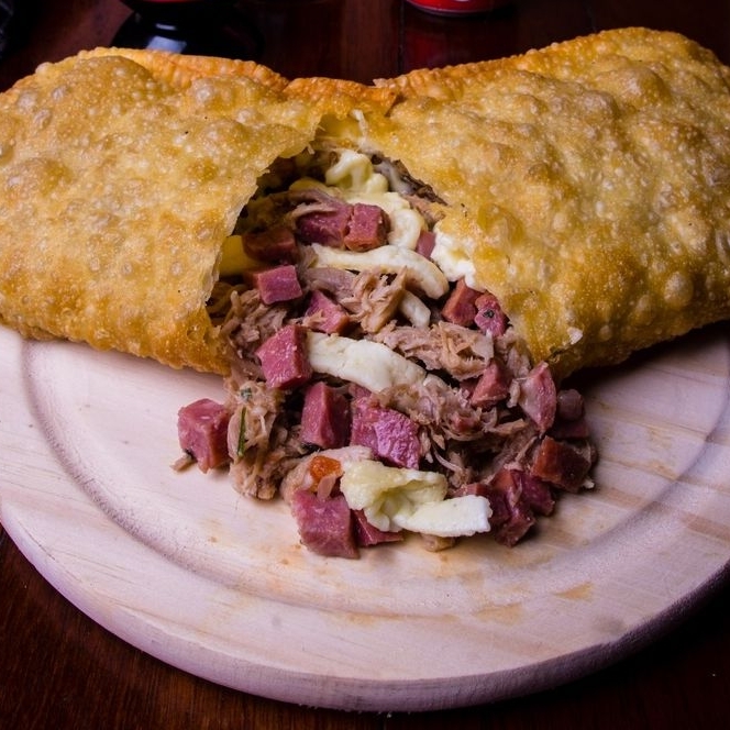 Um pastel recheado com carne moída, bacon, mussarela. Sabor que lembra a casa da mãe!
