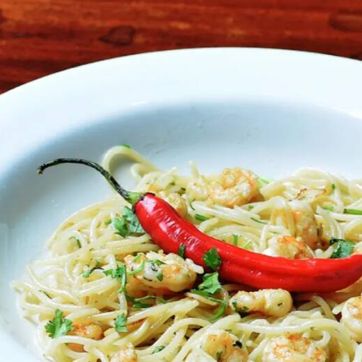 Espaguete ao alho e óleo, acompanhado de deliciosos camarões refogados no azeite, manjericão.