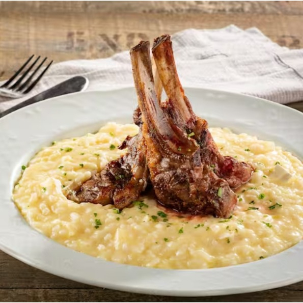 Delicioso e suculento Carré de Cordeiro grelhado na parrilla, que realça o sabor autêntico da carne, com um toque especial de brasa de laranjeira que proporciona uma experiência sensorial única, para aqueles que buscam uma refeição gourmet requintada e saborosa. O prato é harmonizado com um irresistível e cremoso risoto de parmesão, que agrega suavidade e contraste à degustação.