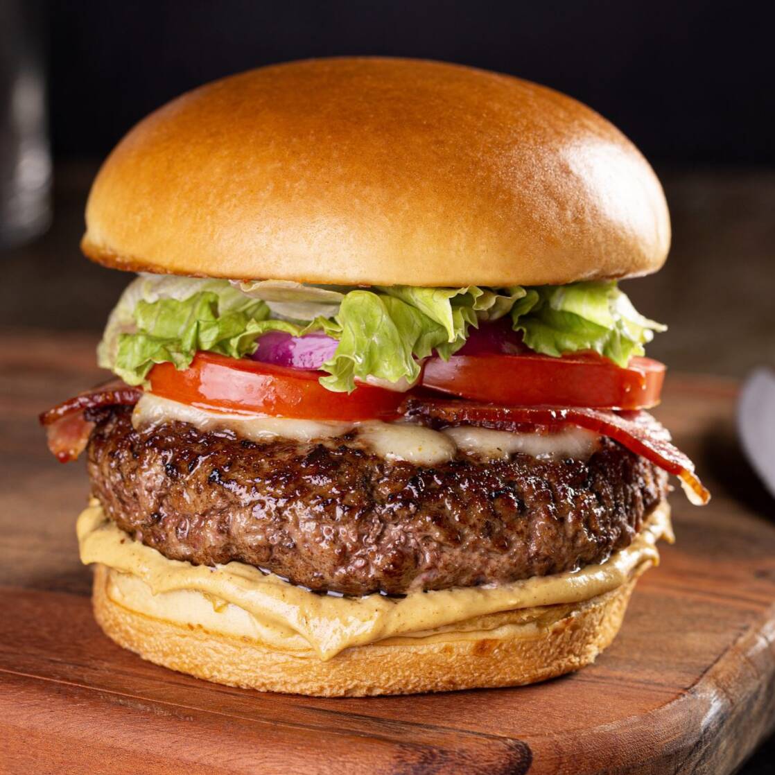 PAO DE HAMBURGUE PINCELADO NA MANTEIGA CARNE DE HAMBURGUE ARTESANAL 75g MOLHO BARBECUE FATIAS DE BACON OVO ALFACE E TOMATE