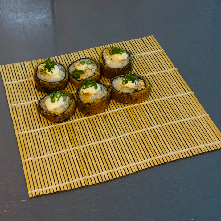 Hot roll empanado e crocante, recheado com salmão grelhado e cream cheese, cortado em unidades e finalizado para proporcionar uma experiência saborosa e irresistível.
