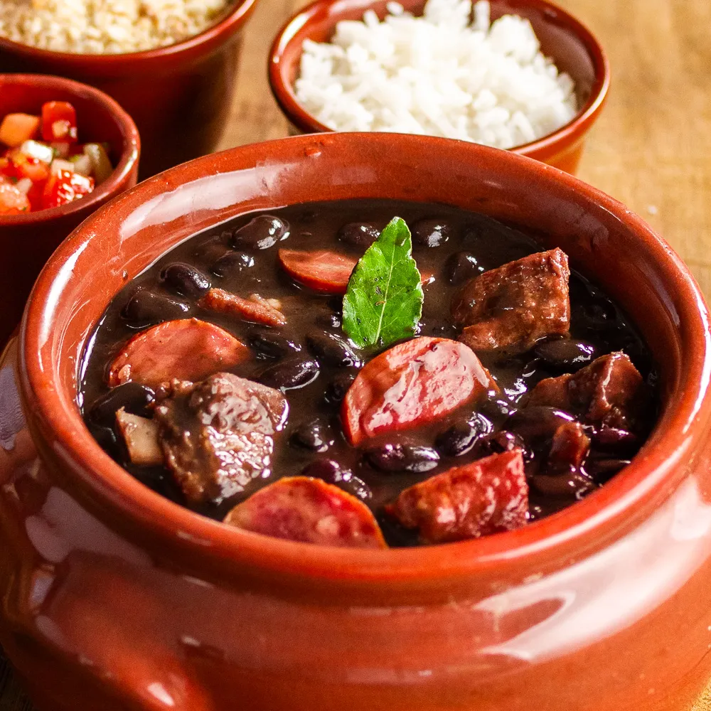 Feijoada Completa preparada com ingredientes selecionados, acompanha: Arroz Branco, Couve Refogada, Torresmo Crocante, Vinagrete + 1 Coca Cola 2L! Já venha experimentar nossas delícias!