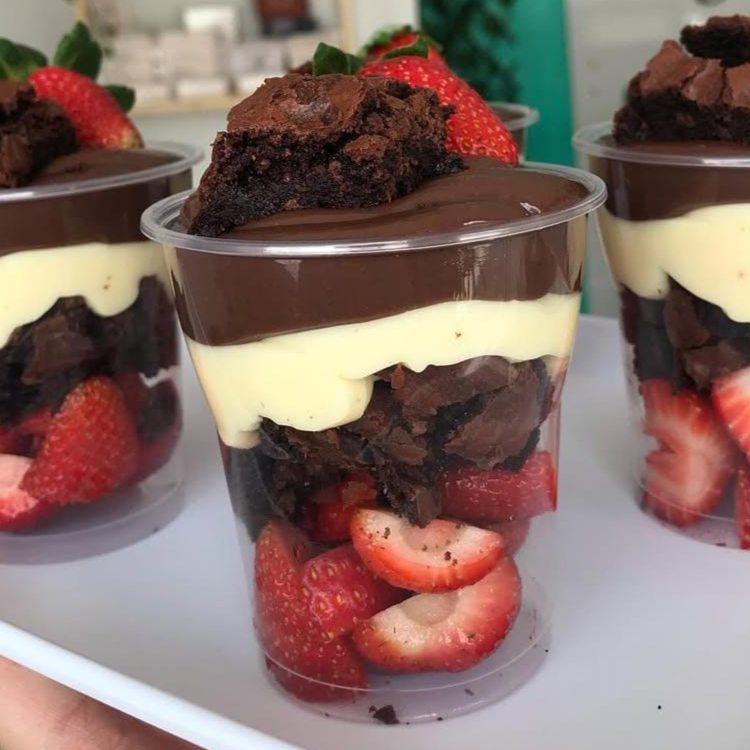 Morangos frescos, pedaços no nosso maravilhoso Brownie molhadinho e bem chocolatudo, uma camada do nosso delicioso creme de Ninho e uma camada do nosso creme de chocolate 50% cacau, finalizado com brownie e morango.