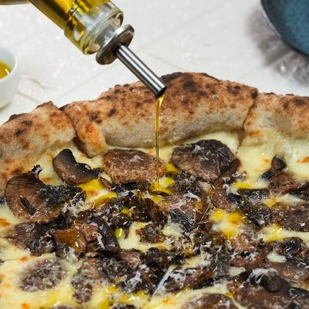 Mozzarella fiordilatte, mix de cogumelos, flor de sal, pimenta do reino, finalizado com queijo grana padano ralado e azeite trufado. Obs: por padrão, a pizza é enviada inteira (não fatiada) para garantir uma melhor conservação e mantê-la quente por mais tempo (além de facilitar caso você queira reaquecê-la no forno ao recebê-la). Se preferir que enviemos a pizza cortada em fatias, favor especificar na observação do pedido ;)