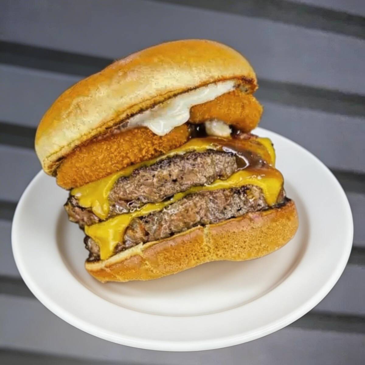 Uma explosão de sabor em cada mordida. Preparado no pão brioche macio, com 2 hambúrgueres suculentos de 130g, maionese da casa, molho barbecue, cebola empanada crocante e generosas fatias de bacon, o combo acompanha uma porção pequena de batata frita e um refrigerante pequeno bem gelado, garantindo uma refeição completa, intensa e irresistível.