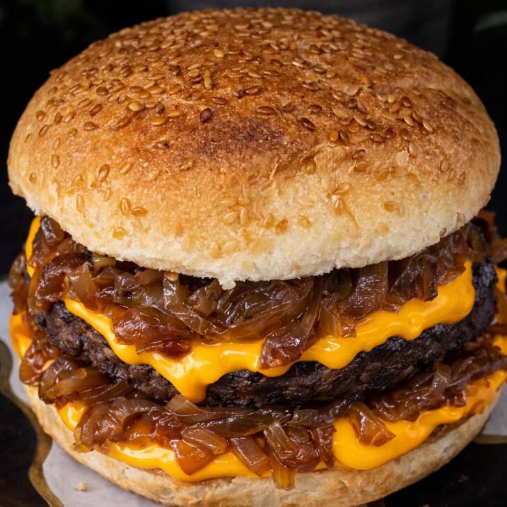 Um delicioso hambúrguer vegetal de 110g, cheddar veg, cebola ao molho shoyu e pão com gergelim.