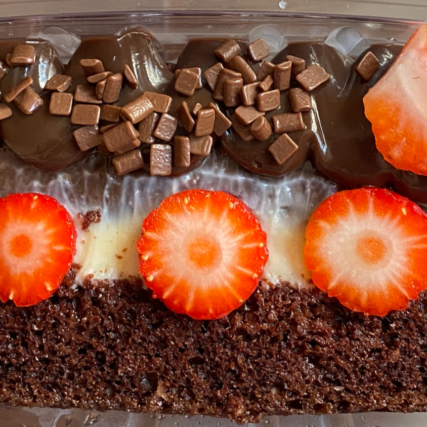 Bolo de chocolate com recheios de ninho e chocolate decorado com morangos