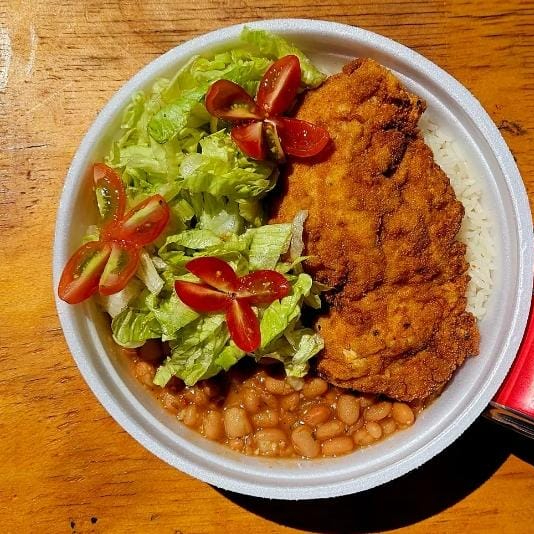 Marmita com delicioso filé de frango empanado super crocante acompanhado de arroz branquinho soltinho, feijão com caldo e salada (alface, tomate e azeitona) enviada separadamente. Marmita P (500 ml), aprox. 400 gramas, indicada para 1 pessoa