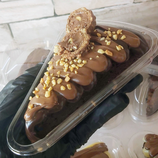 Brownie feito com chocolate nobre meio amargo, com cobertura cremosa de brigadeiro preto e Nutella, amendoim triturado e um Ferrero Rocher para finalizar...Cada mordida é uma explosão de sabor e textura