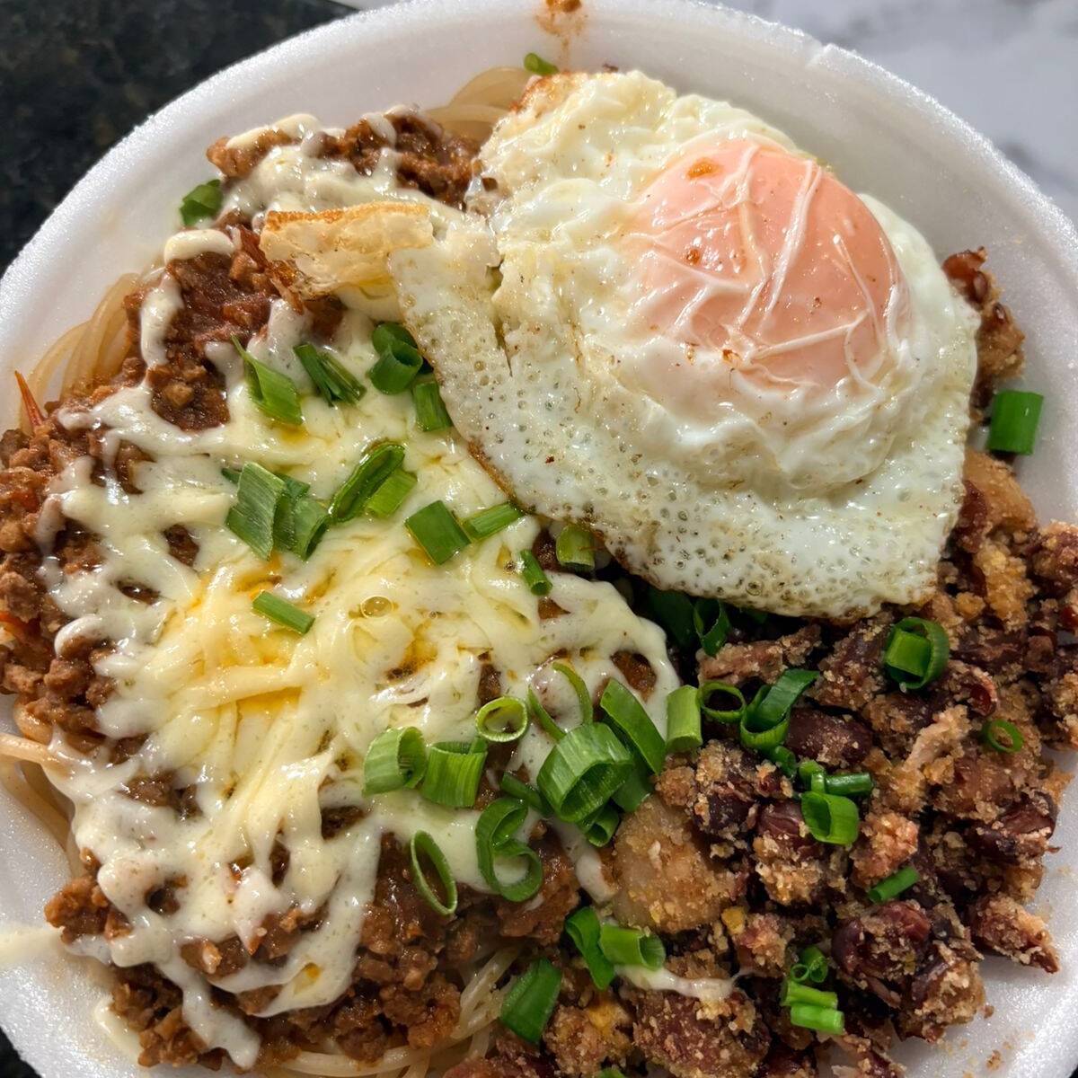 Marmita com feijão tropeiro e espaguete a bolonhesa acompanhada de ovo frito, mussarela e cebolinha