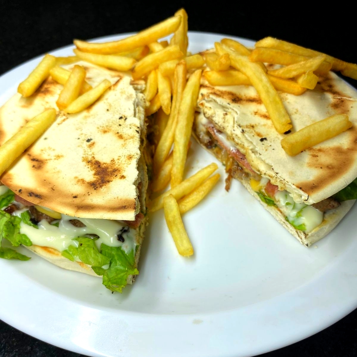 Pão sírio, picanha, queijo, presunto, cebola caramelizada, tomate, alface e batata.