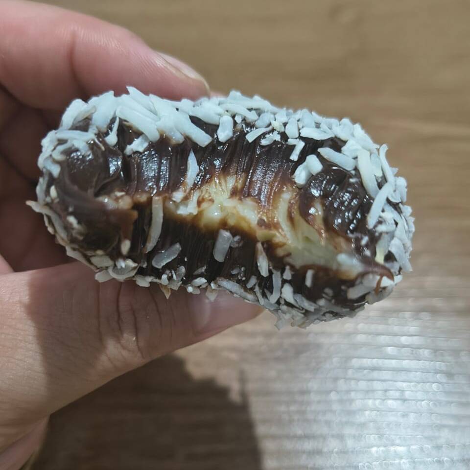 Brigadeiro de chocolate, recheado com brigadeiro cremoso de coco, finalizado com coco fresco.
