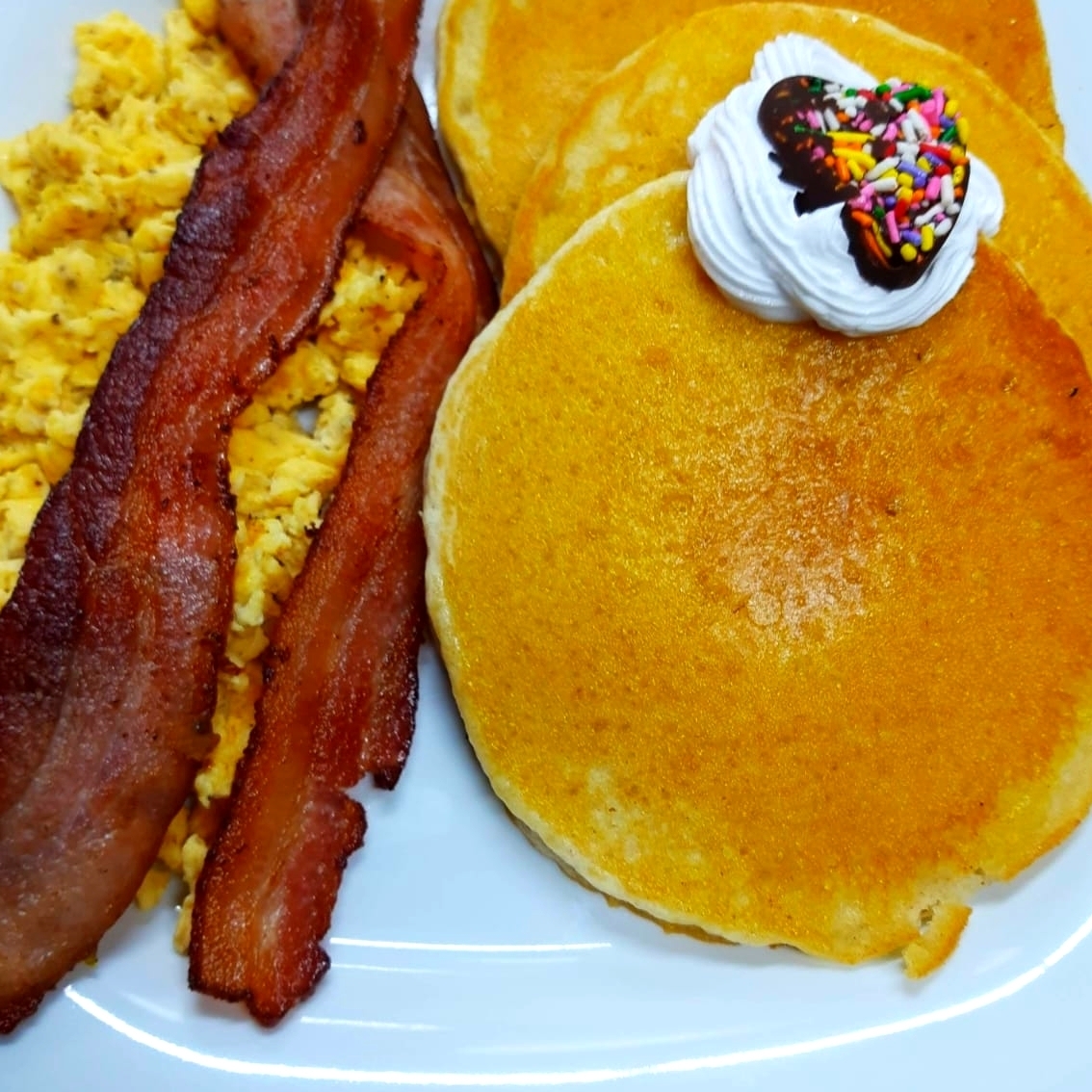 Pancake de mantequilla y huevos revueltos y tocino