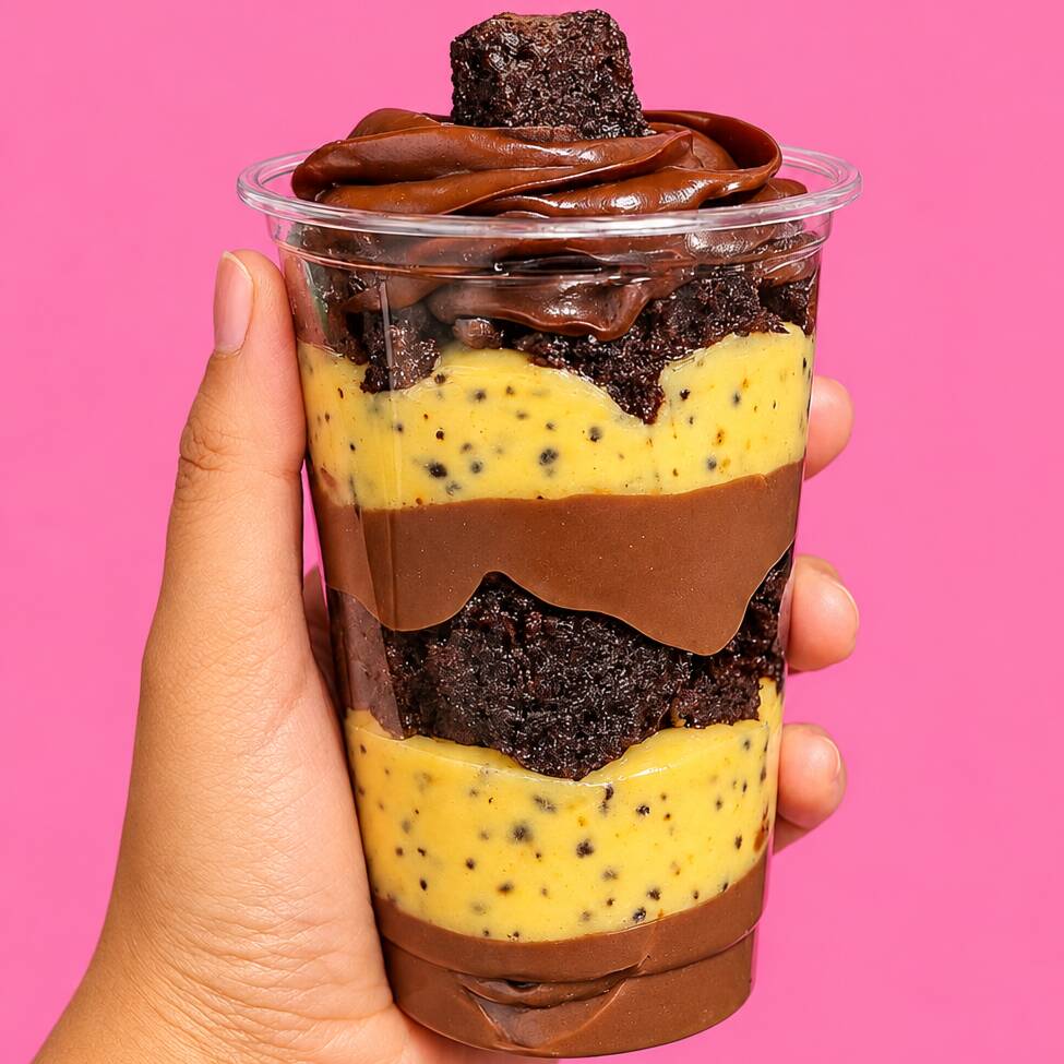 Copo da felicidade com brigadeiro de maracujá, brigadeiro 50% e pedaços de brownie