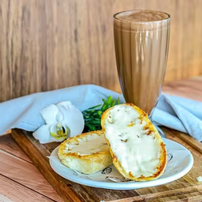 Pão levemente dourado com manteiga na chapa e um toque especial de requeijão cremoso + Chocolate Toddy 500ml para um começo de Dia irresistível!