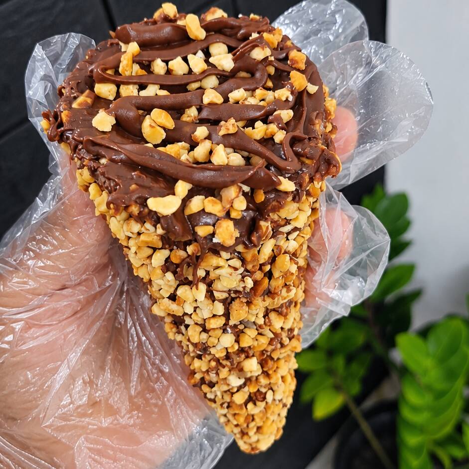 Cone Trufado chocolate amendoim finalizado com nutella
Uma verdadeira explosão de sabor! 🤎
Cone crocante recheado com chocolate ao leite, forrado com amendoim granulado e recheado com uma combinação irresistível de chocolate, amendoim e Nutella. Finalizado com uma generosa camada de chocolate e finalizado com nutella além de amendoim crocante.
✨ Cremoso, crocante e chocolatudo — inspirado no clássico Ferrero Rocher