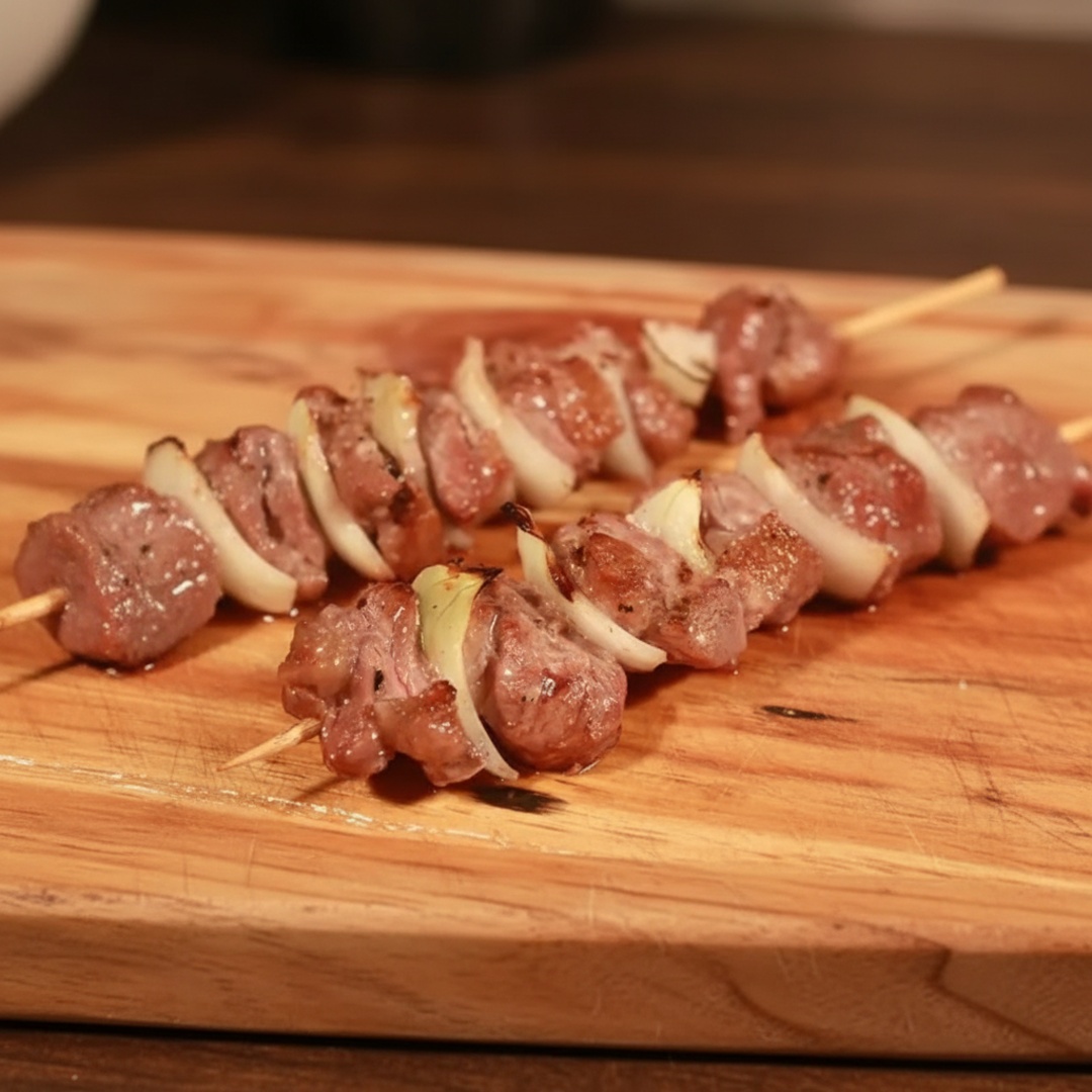 Carne com pedaços de cebola, assado na brasa.