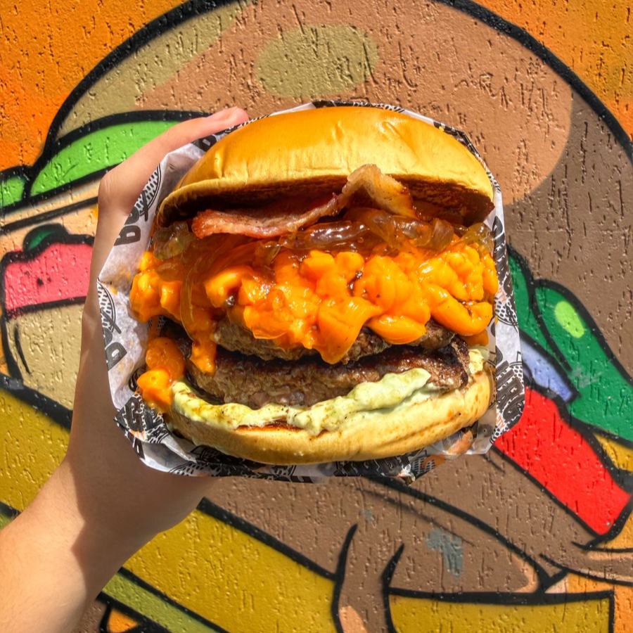 Pão brioche tostado na chapa com manteiga, dois hamburgueres artesanais de aprox 160g cada, cheddar cremoso, bacon, cebola caramelizada e maionese da casa.