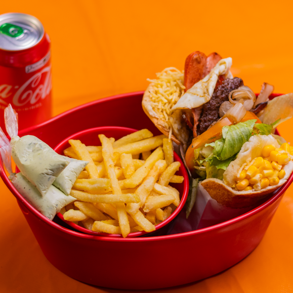 Um X-Tudo completo com muçarela, salsicha, bacon, ovo, alface, tomate, batata palha e milho, acompanhado de refri lata 350ml e batata frita 150g. O combo perfeito para matar a fome!