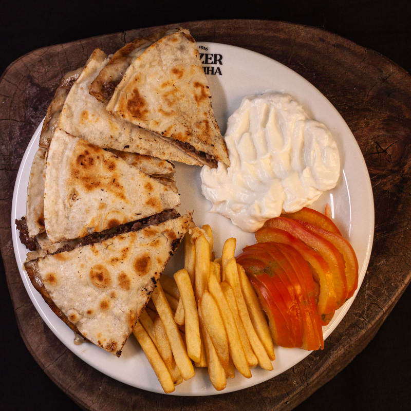 Pão sírio tostado, carne moída, mussarela derretida, tomate e nossa clássica pasta de alho. Acompanha batata frita.