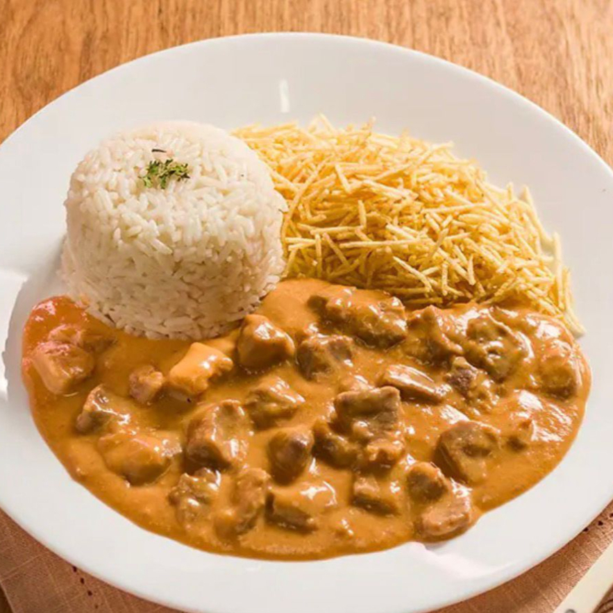 Lascas de Alcatra salteadas com conhaque, regados de creme de leite, molho de tomate e especiarias, servido com arroz branco e batata palha.