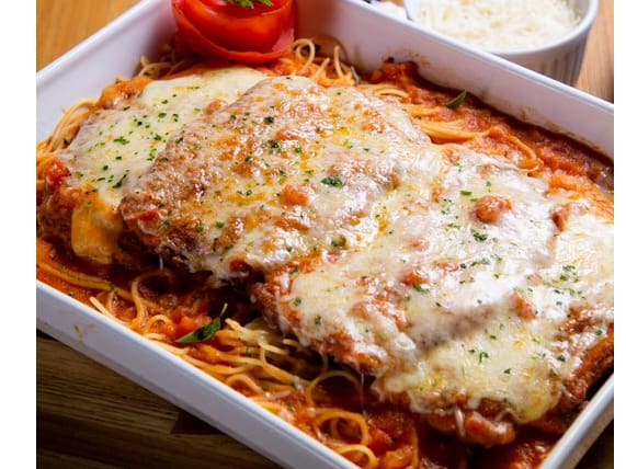 Filé de frango à milanesa envoltos em molho caseiro de tomate fresco e gratinado com queijos mussarela e parmesão. Servido com espaguete no próprio molho.