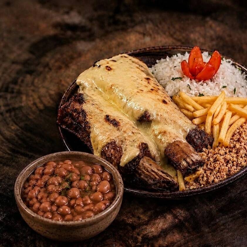 Executivo de costela tradicional com queijo, arroz branco, feijão carioca, batata frita crocante e farofa. Churrasco executivo, entrega rápida, frete grátis.
Seo: executivo de costela na brasa com queijo, marmita de costela na brasa, marmitex de costela com queijo derretido, quentinha de costela assada, prato executivo de churrasco, costela bovina suculenta, almoço com costela na brasa, refeição completa com arroz e feijão, acompanhamento de farofa crocante, comida caseira, sabor de churrasco tradicional, costela com queijo gratinado, porção individual bem servida, frete grátis, entrega rápida, cupom de desconto exclusivo, promoções especiais no ifood, melhor custo benefício, marmita de costela com qualidade, refeição prática para o Dia a Dia, almoço executivo no app, comida feita na hora, prato farto e saboroso, marmita quentinha, carne assada lentamente, tempero especial da casa, opção para almoço no trabalho, combo executivo de costela, prato do Dia, grátiz