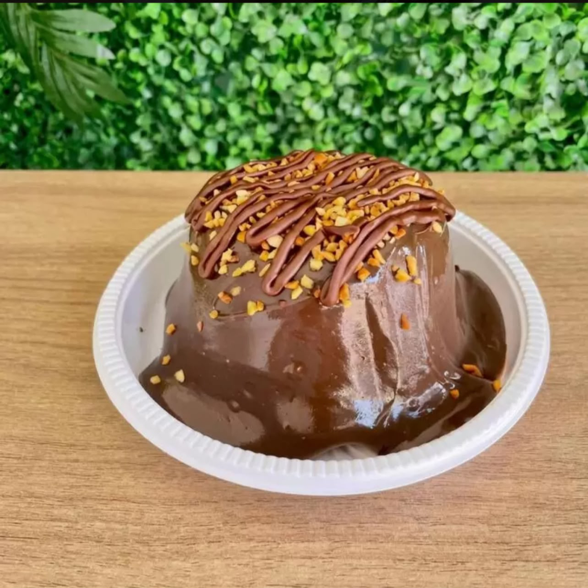 Massa de chocolate, com cobertura de brigadeiro de chocolate, granulado de amendoim e fios de nutella.