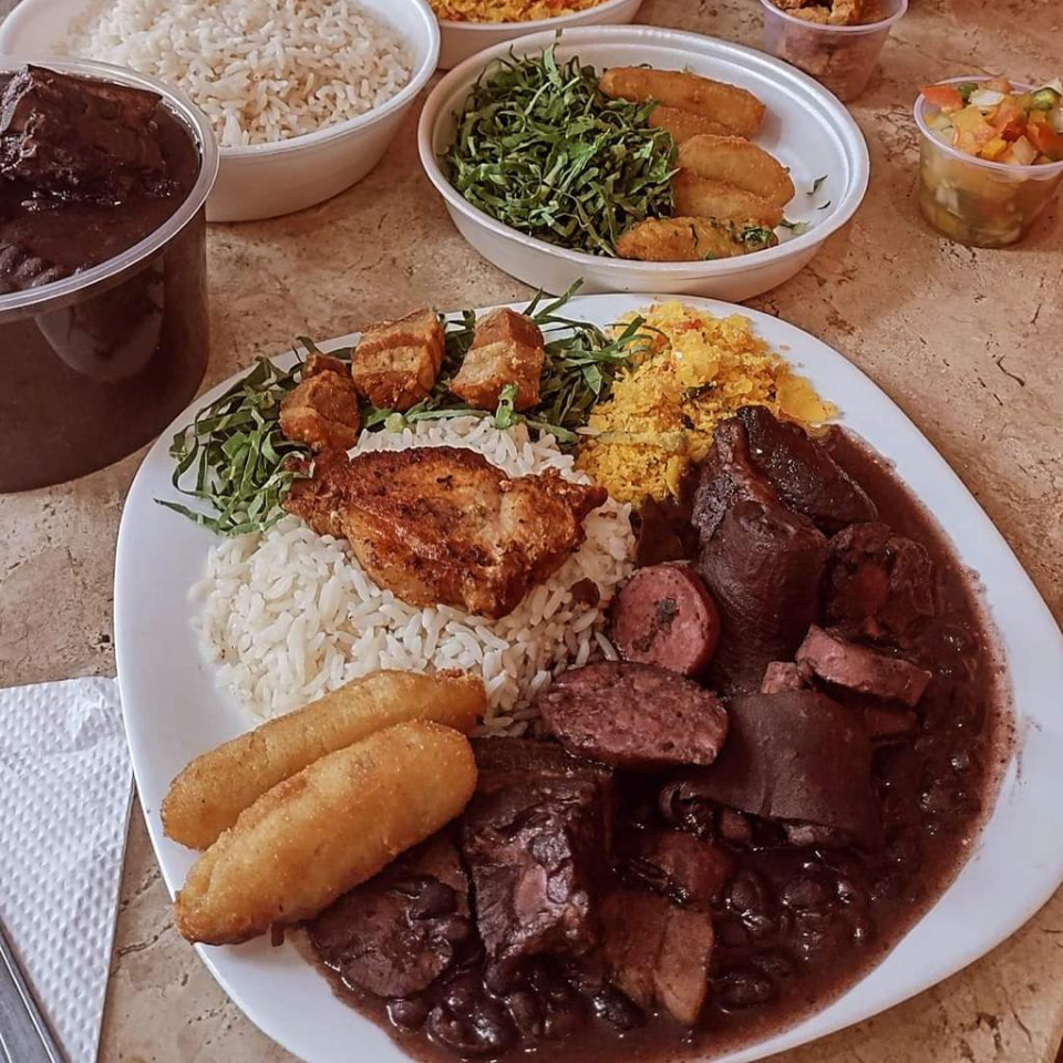 Feijoada (feijão, calabresa, paio, costelinha defumada, bacon, rabo e pé), arroz, farofa, couve, banana à milanesa, torresmo, bisteca e vinagrete