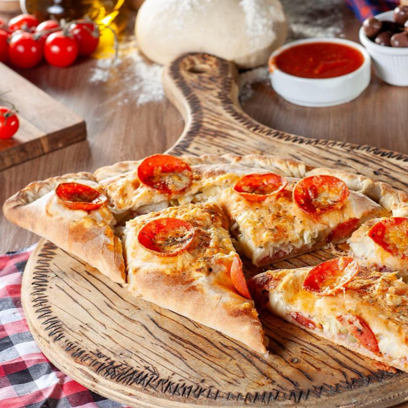 Todos calzones são sem borda e com pepperoni e parmesão por cima da massa.