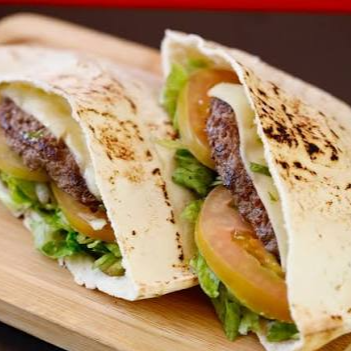 Pão Sírio, 2 hambúrgueres, 2 queijos, Orégano, azeite e salada.
